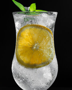 Refreshing Sparkling Citrus Drink With Orange Slice and Fresh Mint on Dark Wooden Background