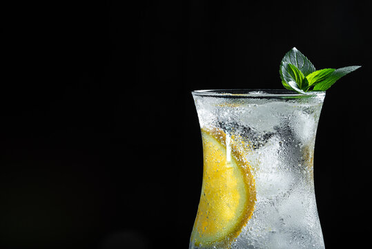 Refreshing Sparkling Citrus Drink With Orange Slice and Fresh Mint on Dark Wooden Background