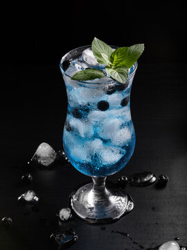 Refreshing Blueberry Mocktail With Mint Leaves and Ice in Glass on Black Background