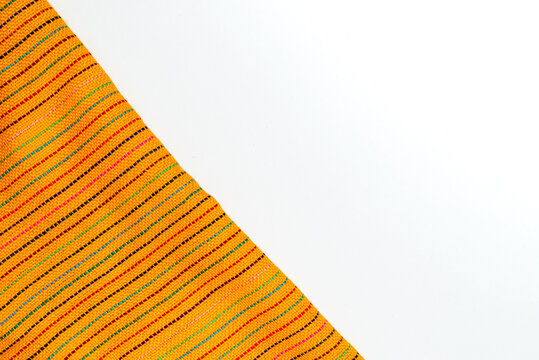 Traditional Mexican Yellow Textile with Colorful Threads on a White Surface