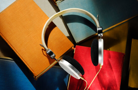 audiobook withh multicolored books and headphone, narrrow depth field, close up