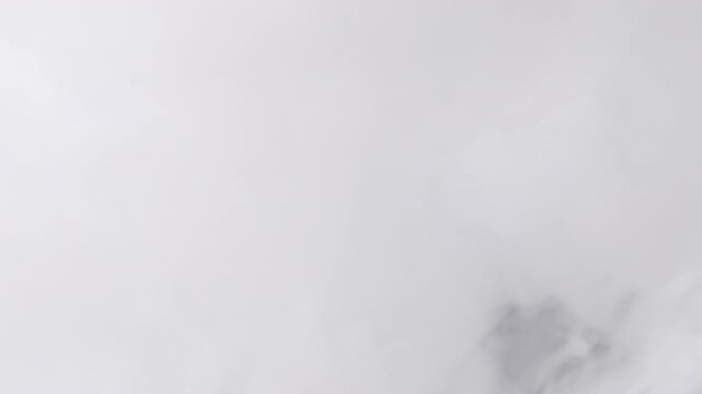 Slow motion closeup vapor stream from right on black background