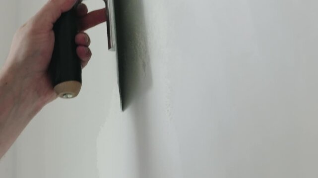 Slow motion closeup worker applying decorative concrete plaster on the wall