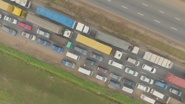 Top-down aerial view of heavy traffic at a standstill across a busy Lagos road in Nigeria, showing dense lines of cars and urban congestion