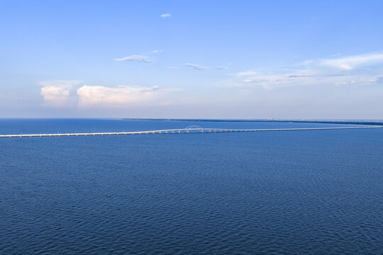 Aerial view of Pensacola Bay Bridge spanning the blue waters of the bay under a clear sky in Gulf Breeze, Florida, United States.
