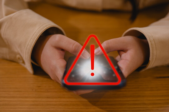 Girl hand or businesswoman using smartphone with red triangle warning sign in concept of risk notification error and maintenance warning and safety privacy data security, risk management