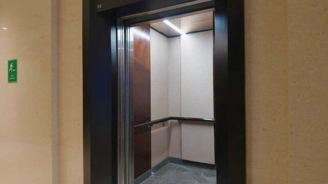 Modern Elevator with Open Doors Inside a Residential Building Corridor.