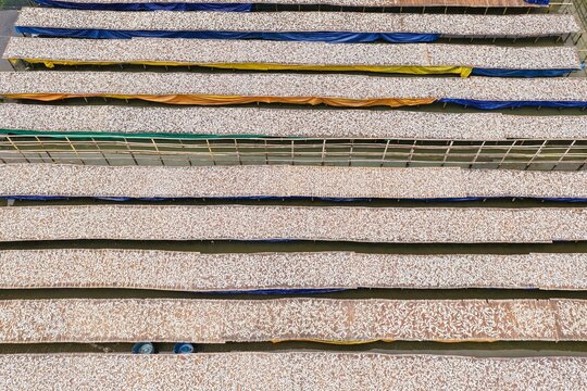 Aerial view of traditional fish drying racks arranged in parallel rows with colorful tarps at the famous drying yards in Cox's Bazar, Chittagong Division, Bangladesh.