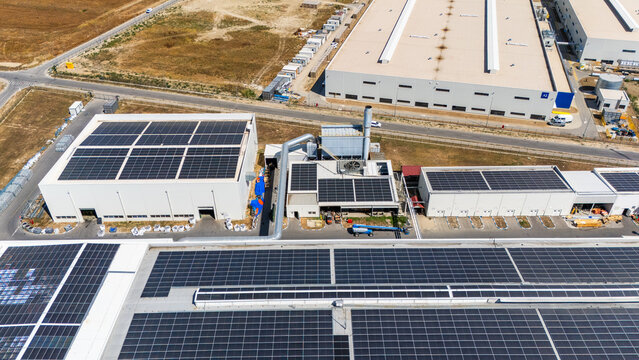 Aerial view of industrial warehouses featuring extensive rooftop solar panel installations in an industrial zone in Sabac, Vojvodina, Serbia.