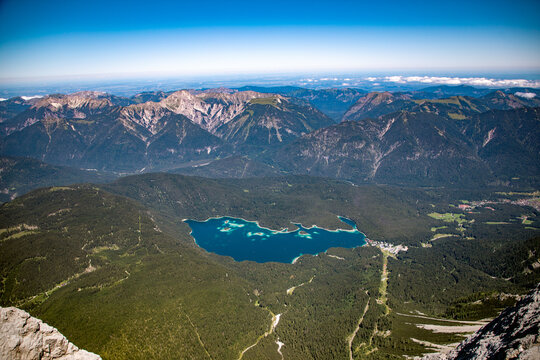 Aerial view of Eibsee lake surrounded by dense forests and the dramatic peaks of the Wetterstein mountains in the Bavarian Alps, Grainau, Bayern, Germany.