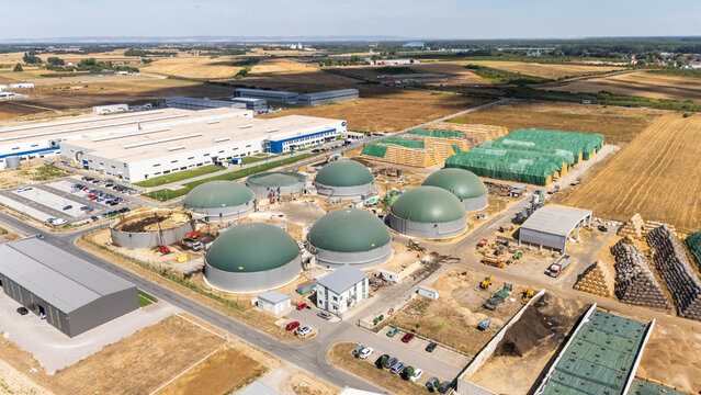 Aerial view of a biogas plant with large green fermentation domes, industrial facilities, and surrounding agricultural fields in Sabac, Vojvodina, Serbia.