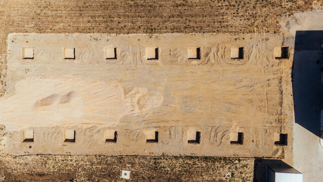 Aerial view of a construction site with evenly spaced square foundation pits in the dry earth in Sabac, Vojvodina, Serbia.