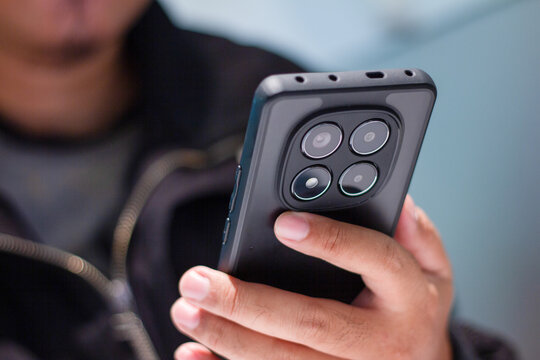 Hands holding a modern smartphone with a bright screen, engaging in online communication and mobile apps