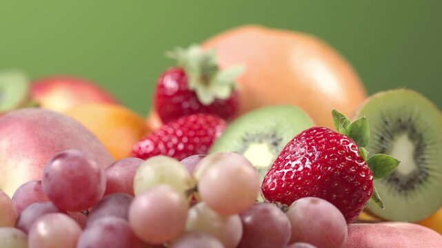 assorted fresh colorful fruits and berries rotating in a vibrant composition. Juicy peach, orange, strawberries, blueberries, kiwi, and grapes