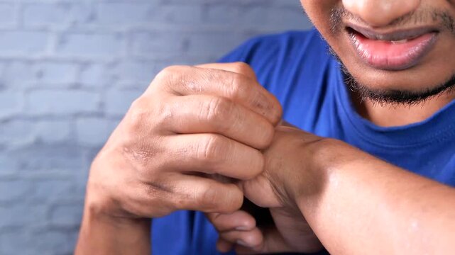 Man experiencing pain and discomfort in wrist, holding hand in agony