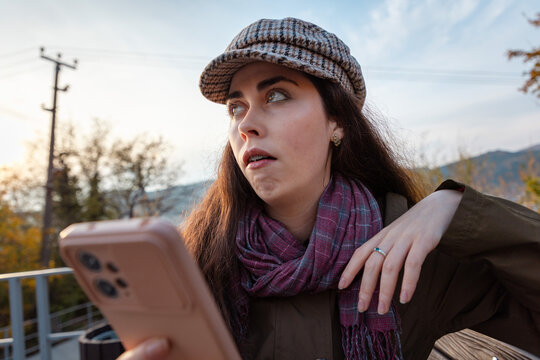 Portrait of young woman reacting with visible disdain while checking smartphone screen. Judgment and social communication concept.