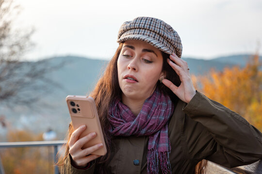 Young woman looking puzzled and unimpressed while browsing smartphone content. Critical thinking and communication concept. Mid shot