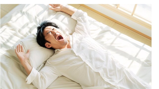 A middle-aged man wakes up with a big yawn while lying on his futon