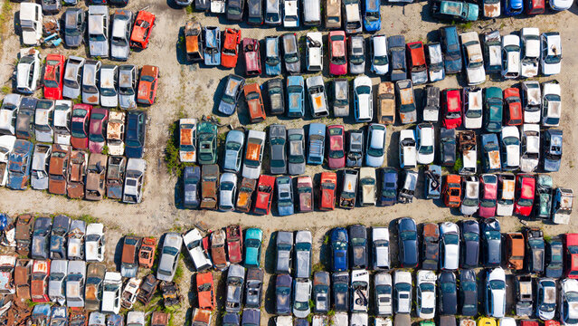 Aerial view of a car dump with rows of old and salvaged vehicles parked in an open lot in San Giuliano Milanese, Lombardy, Italy.