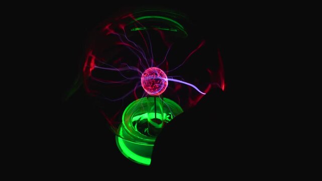 Close up video of a human hand touching a glowing plasma ball, attracting electric discharges and bright neon light beams against a black background.