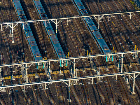 Aerial view of stabled metro trains parked on parallel tracks at an electric train depot with overhead railway gantries in Tallawong, New South Wales, Australia.