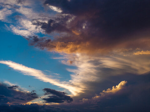 Aerial view of dramatic storm clouds illuminated by the golden light of sunset over the landscape in Fountain, CO, United States.
