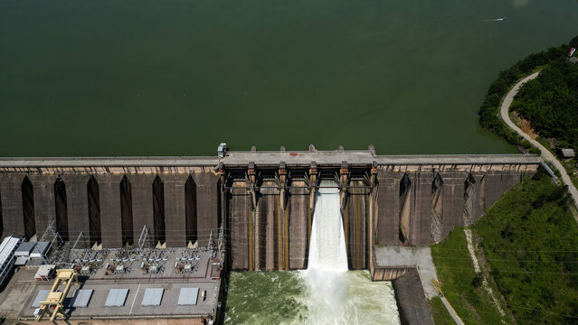 Aerial view of the Bajina Basta Hydroelectric Power Plant with water rushing through the spillway, concrete dam structure, and surrounding green landscape in Perucac, Zlatibor District, Serbia.
