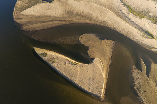 Aerial view of low water levels in a river bed revealing intricate sandbanks and natural patterns in Poland.