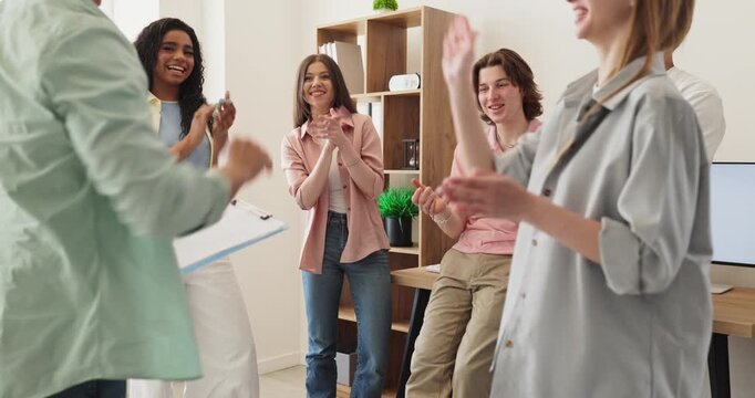 Students in classroom team highfive in celebration. They cheer and smile in a bright room after working together on a shared project. Teamwork shines. Strong message of unity and success.