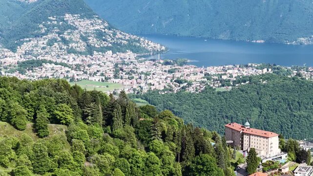Aerial panorama of Ticino, Switzerland, overlooking Lake Lugano, forested hills and lakeside settlements, combining Mediterranean scenery with dramatic alpine terrain and peaceful southern Swiss