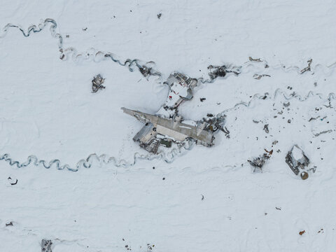 Aerial view of the historic C-124 Globemaster II crash site on Bomber Glacier, featuring scattered aircraft wreckage embedded in the snow-covered Matanuska-Susitna Borough, Alaska, United States.