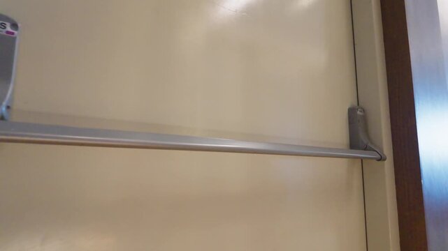 Emergency exit push bar mounted on a secure metal building door.