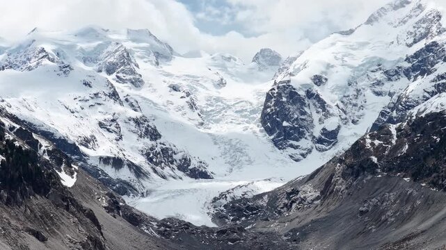 Dramatic aerial view of Morteratsch Glacier in Engadin, Graub&uuml;nden, Switzerland, surrounded by rugged snow-covered peaks and a vast alpine landscape.