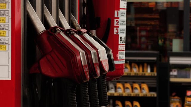 Fuel pumps at a gas station, representing gasoline, fossil fuel dependence, rising energy costs, transportation and the global energy crisis.