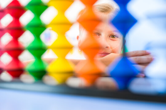 Young girl visualizing and practicing mental arithmetic with a colorful abacus, developing concentration, calculation and cognitive skills.