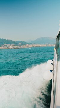 Buoy fenders swinging over foaming water as a port draws near Amalfi