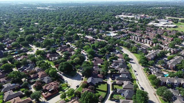Single family residential subdivisions intersect Parkway Boulevard near Saint Ann Catholic Parish. Dense deciduous canopies, private backyards, curved roadways span peaceful Coppell, Texas.