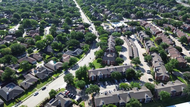 Residential neighborhoods converge around Parkway Boulevard near Saint Ann Catholic Parish. Clustered apartment complexes, private backyard pools, curving suburban roadways frame Coppell, Texas.