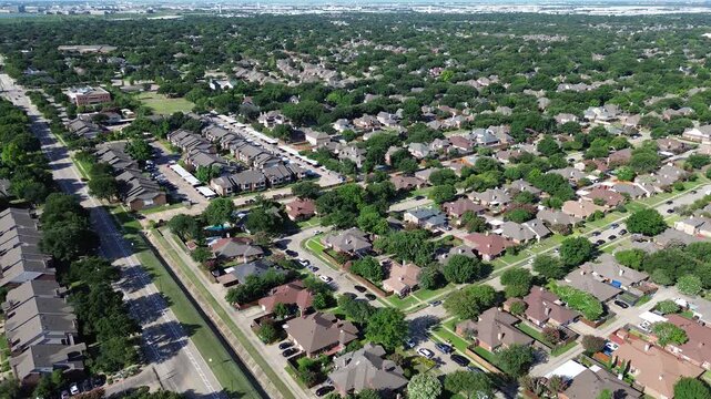 Suburban residential neighborhoods surround Parkway Boulevard near Town Center Elementary School. Brick single family residences, curving cul-de-sacs, dense green foliage fill Coppell, Texas.