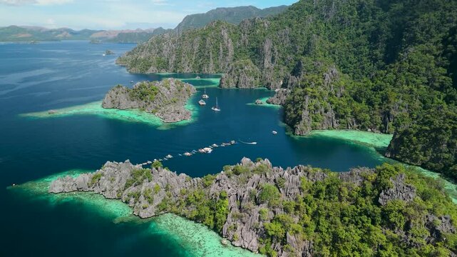 Aerial view of tropical lagoon in Coron Palawan Philippines featuring limestone cliffs and crystal clear turquoise ocean water.