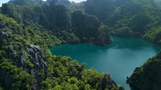 Aerial view of tropical lagoon with turquoise water surrounded by limestone cliffs in Coron Palawan Philippines.