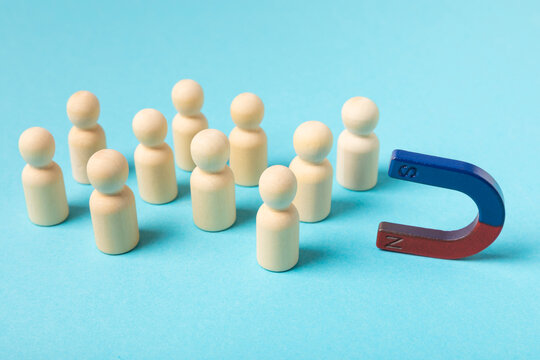 Magnet attracting human figures, concept of leadership, teamwork, social connection, cooperation and attraction of people. Magnet for your customers, clients or human resources. Marketing and manageme