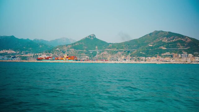 Industrial port of Salerno with colourful containers below rocky green peaks
