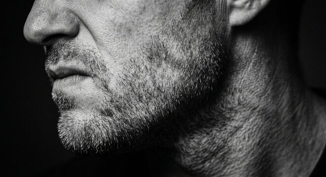 Moody black and white close-up of man jawline with stubble