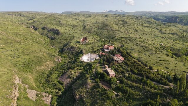 Aerial view of the Radio Optical Observatory ROT-54 featuring its large radio telescope dish set within the rugged green hills of Orgov, Aragatsotn Province, Armenia.