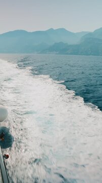 Wake streaming alongside a hull toward Amalfi coast in Italy