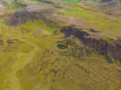 Aerial view of moss-covered volcanic lava fields and rugged craters in Reykjanesbaer, Iceland.