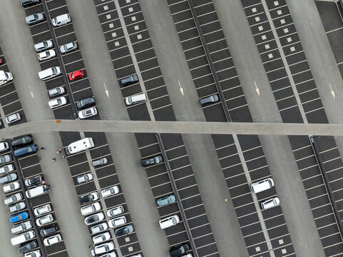 Aerial view of a large parking lot with numerous cars parked in marked spaces, showing organized rows and asphalt pavement in Reykjanesbaer, Iceland.