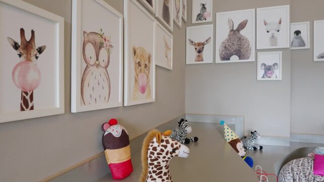 Cozy modern children bedroom interior with cute animal posters and plush toys on the shelf.