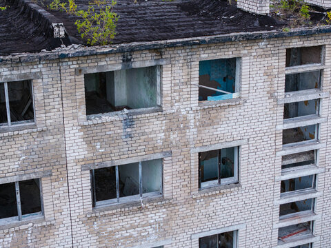 Aerial view of the abandoned Soviet military ghost town of Irbene, featuring decaying brick apartment buildings with empty windows and overgrown rooftops in Irbene, Ventspils Municipality, Latvia.